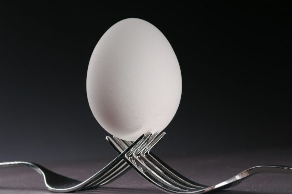 a fork with an egg on top of it